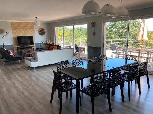 une salle à manger et un salon avec une table et des chaises dans l'établissement LE CLOS DE BAJARDAN, à Couloumé-Mondébat