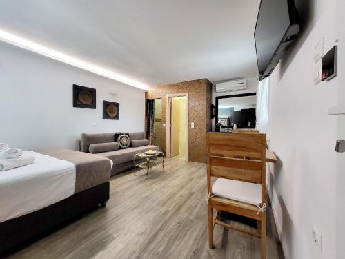 a hotel room with a bed and a couch at Mykonos Double Luxury Mini Suites-With External Hot spa Adults only in Ano Mera