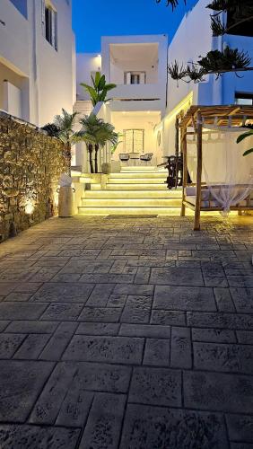 a building with a stone courtyard with stairs in front at Mykonos Double Luxury Mini Suites-With External Hot spa Adults only in Ano Mera