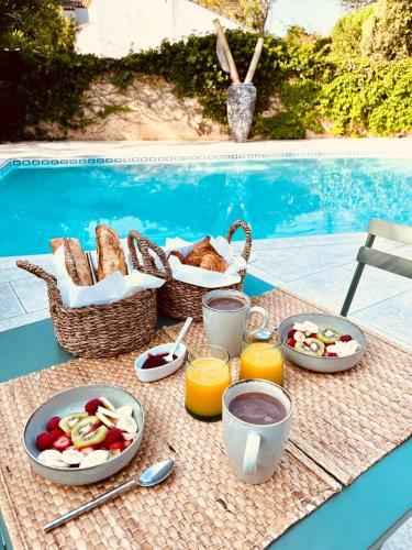 - une table avec de la nourriture et des paniers de pain et de jus d'orange dans l'établissement Romance en Provence, à Marignane