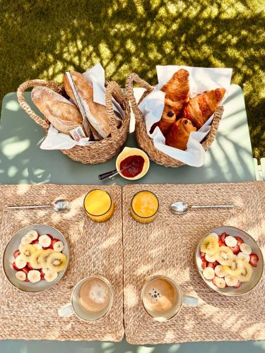 uma mesa com duas cestas de pão e outros alimentos em Romance en Provence em Marignane