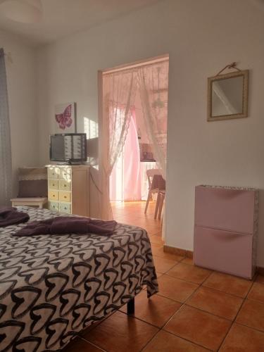 una camera con letto, televisore e finestra di Sol y Sombra Apartamento con entrada independiente a Isla del Moral