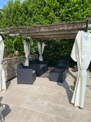 a pergola with chairs and tables on a patio at jolie appartement avec piscine in La Roquette-sur-Siagne