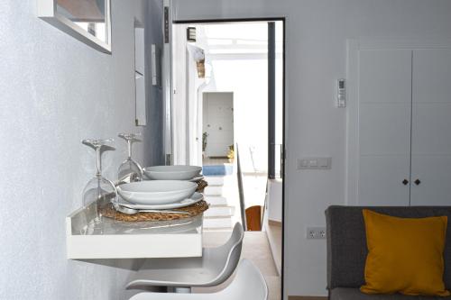 uma casa de banho com um lavatório de vidro e um espelho. em Loft La Abuela em Vejer de la Frontera