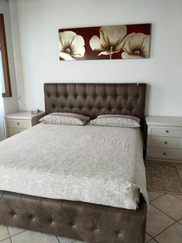 - une chambre avec un lit doté d'une tête de lit touffetée dans l'établissement Casa Vacanze a 2 passi dal mare, à Carrara