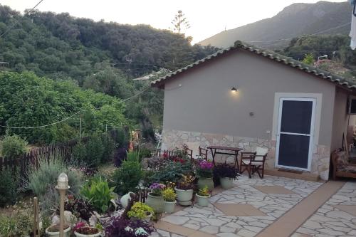 a house with a patio and a table and chairs at Lambrini Studios in Parga
