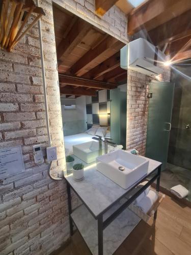 baño con lavabo en una pared de ladrillo en Loft 41 by Casa Matia, en San Miguel de Allende