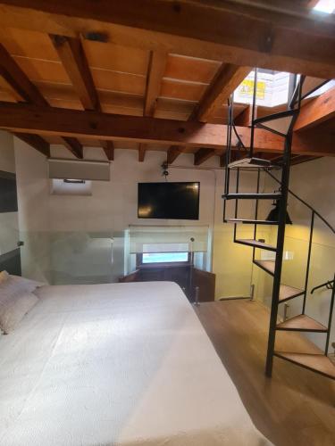 Dormitorio tipo loft con cama y TV en la pared en Loft 41 by Casa Matia, en San Miguel de Allende
