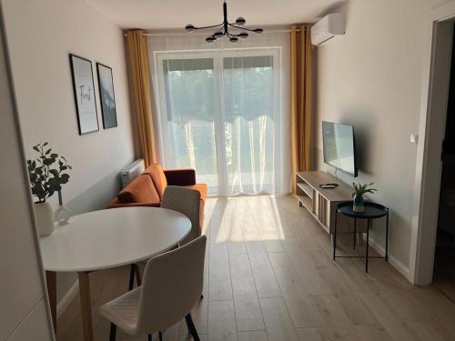 a living room with a white table and a television at Apartamenty Akademicka przy Onkologii 1 in Bydgoszcz