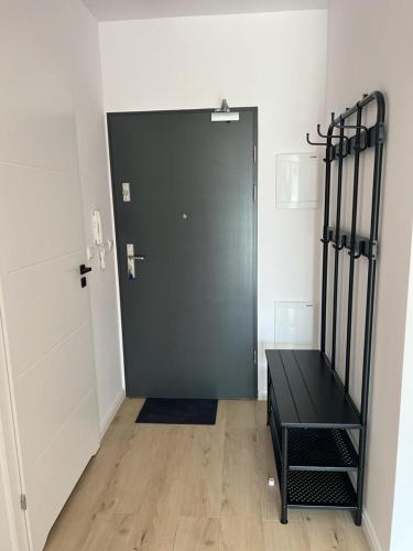 a black door in a room with a wooden floor at Apartamenty Akademicka przy Onkologii 1 in Bydgoszcz