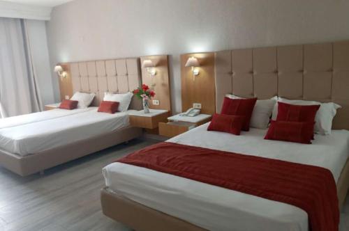 a hotel room with two beds with red pillows at Djerba Holiday Beach in Midoun