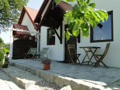 a house with chairs and a table on a patio at Domki Zielona Osada in Szczenurze