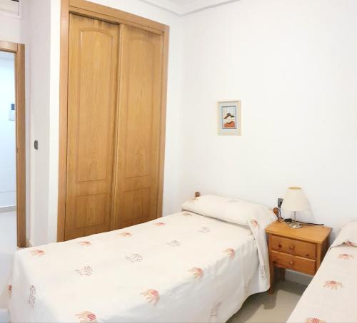 グアルダマル・デル・セグラにあるGuardamar Centroのベッドルーム1室(ベッド2台付)、木製のドアが備わります。