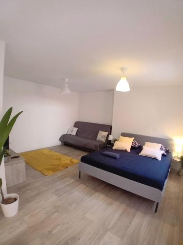 Habitación con 2 camas y sofá. en Petit appartement avec terrasse en Guebwiller