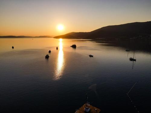 a sunset on a lake with boats in the water at Torbahan Hotel in Torba