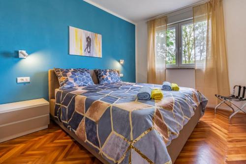 a bedroom with a large bed with blue walls at New two bedroom apartment Maloni in Pula