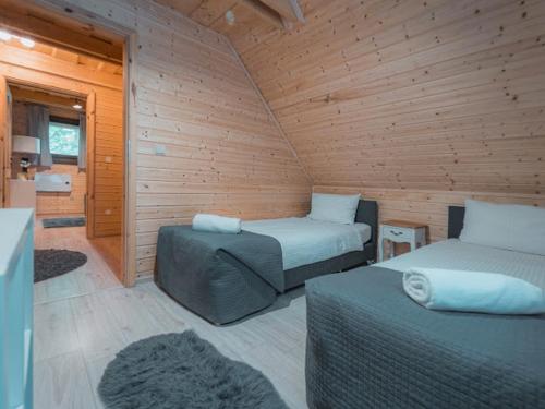 a room with two beds and a chair in a cabin at Drevenice Wars & Sawa in Oščadnica