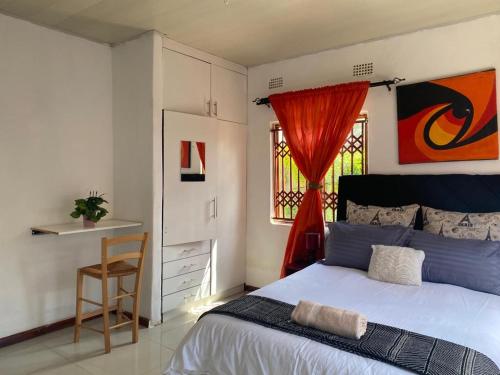 a bedroom with a bed and a chair and a window at Samkab Legacy & comfort Ndeke (airport) in Lusaka
