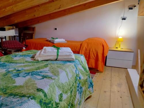 a bedroom with two beds with orange comforters at San Leonardo Country House in Calangianus