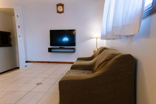 sala de estar con sofá y TV de pantalla plana en Casa Roca en Ushuaia