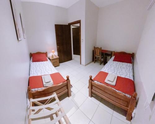 Habitación con 2 camas y una silla. en Casa Roca en Ushuaia