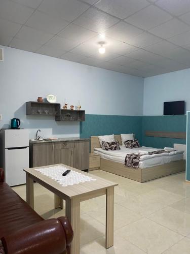 a room with two beds and a table in it at Lind Hotel and Guest House in Gyumri