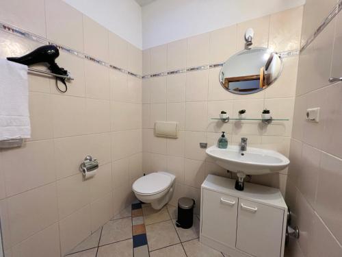 a bathroom with a toilet and a sink and a mirror at 85qm - Zentrale Lage - Parkplatz in Göttingen