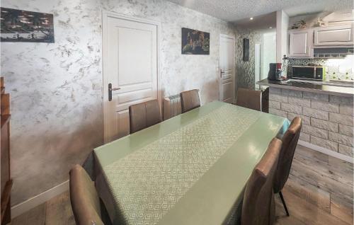 une cuisine avec une table et des chaises vertes et une porte dans l'établissement 2 Bedroom Cozy Home In Portiragnes, à Portiragnes