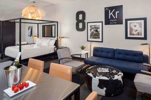 a living room with a bed and a blue couch at Hotel Grinnell, Ascend Hotel Collection in Grinnell