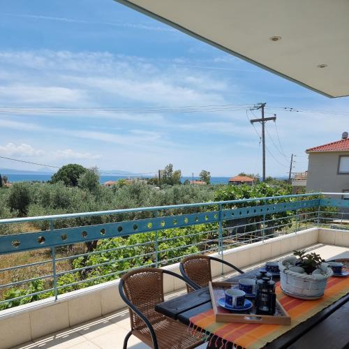 a table on a balcony with a view of the ocean at Vlasis home in Nafpaktos