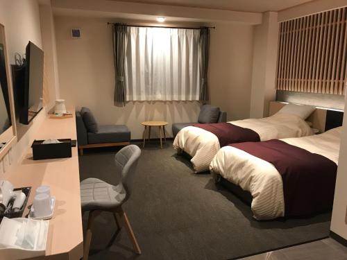 a hotel room with two beds and a television at Aizu Tsuruya Hotel - Vacation STAY 57216v in Aizuwakamatsu