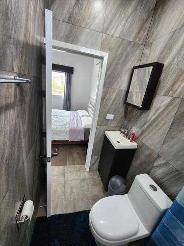 La salle de bains est pourvue de toilettes, d'un lavabo et d'un miroir. dans l'établissement habitaciones disponibles con baño privado zona centro, à Cunduacán