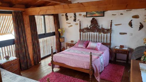 een slaapkamer met een bed met roze lakens en roze kussens bij Casa do Alto das Fragas in Canedo de Basto