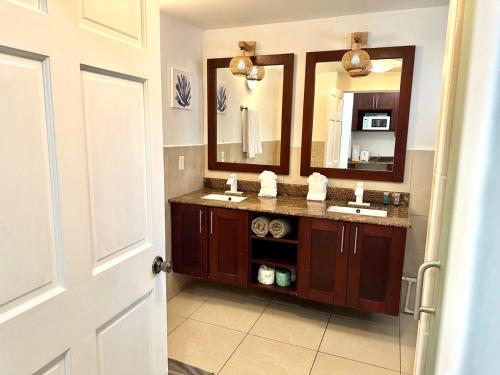 a bathroom with two sinks and a large mirror at Pirates Booty Beach Bar Studio next to The Morgan Resort in Maho Reef