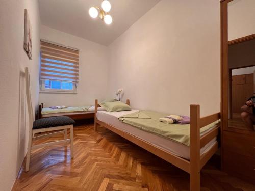 two twin beds in a room with a window at DALIA Apartment & Room in Mostar