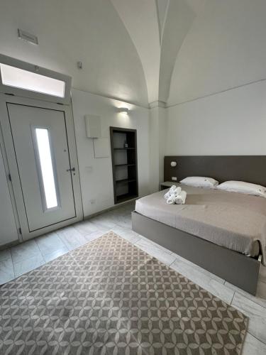 een slaapkamer met een groot bed en een tapijt bij Affittacamere Pagano P.Cesareo in Porto Cesareo
