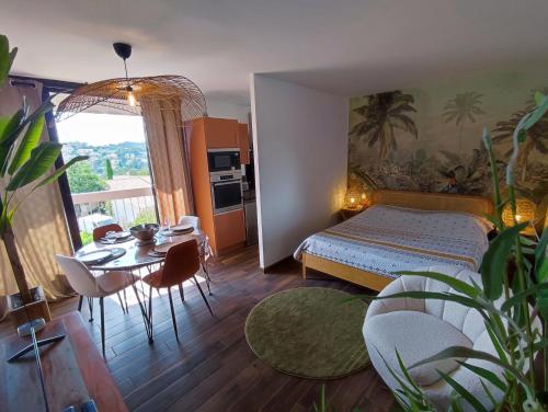 1 dormitorio con cama, mesa y comedor en L'oasis du château ! "climatisé" en Gréoux-les-Bains