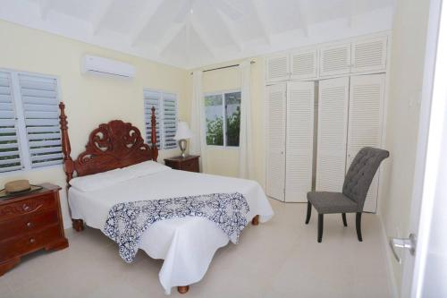 a bedroom with a large bed and a chair at Richmond - Heroes Villa, AC, Security, Access to Pool, Playground & Private Beach - Welcome Breakfast Basket in Richmond