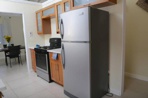 a kitchen with a white refrigerator and a stove at Richmond - Heroes Villa, AC, Security, Access to Pool, Playground & Private Beach - Welcome Breakfast Basket in Richmond