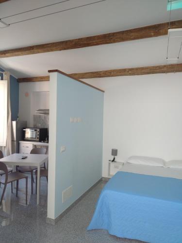 ミラッツォにあるLA REGGIA APARTMENTS MILAZZOのベッドルーム1室(ベッド1台、テーブル付)、キッチン