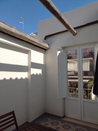 a white house with a door and a window at LA REGGIA APARTMENTS MILAZZO in Milazzo
