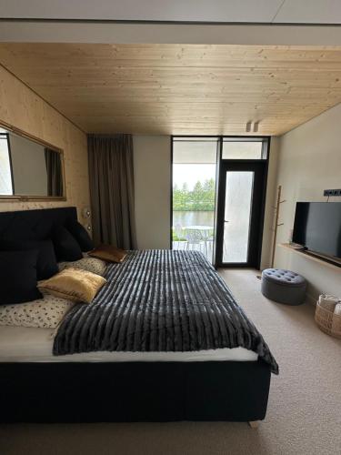ein Schlafzimmer mit einem großen Bett und einem TV in der Unterkunft Penati golf by Kate in Šajdíkove Humence