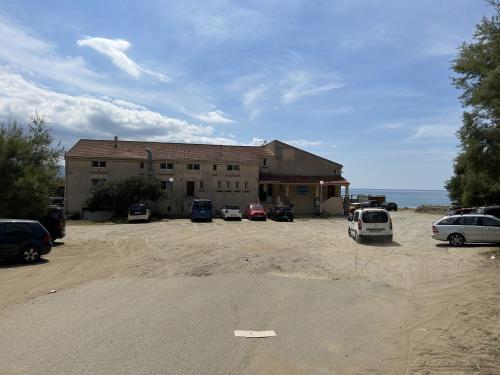 a large building with cars parked in a parking lot at appartement 2 bord de mer in Farinole