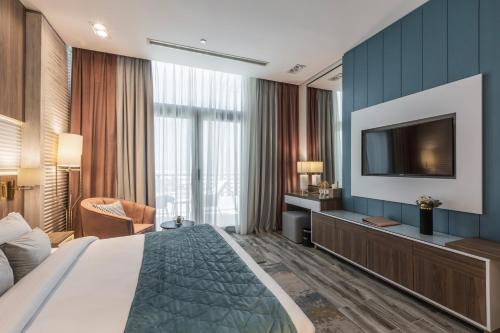 a hotel room with a bed and a flat screen tv at Gewan White Beach Resort-New Alamein in Marsa Matruh