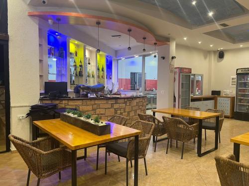 un ristorante con tavoli e sedie e un bar di Hotel Ronaldo a Ksamil