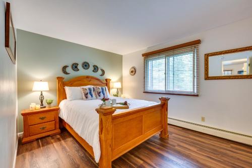 a bedroom with a wooden bed and a window at Estes Park Condo Rental Balcony with River Views! in Estes Park