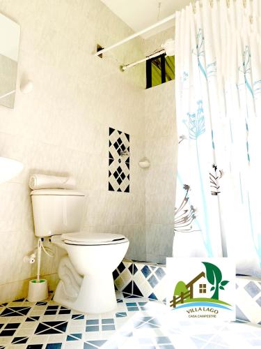 a bathroom with a white toilet in a room at Casa Campestre Villa Lago in Quebradanegra