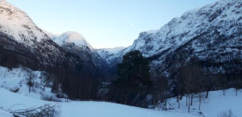 a snowy mountain range with trees and snow covered mountains at Stalheim Fjord og Fjellhytter in Stalheim