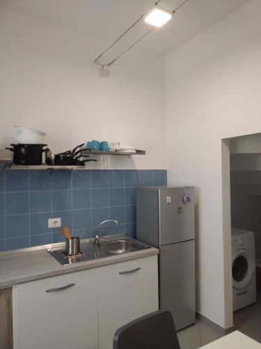 a small kitchen with a sink and a refrigerator at LA REGGIA APARTMENTS MILAZZO in Milazzo