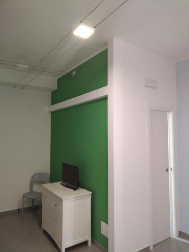 an office with a green wall and a desk with a laptop at LA REGGIA APARTMENTS MILAZZO in Milazzo
